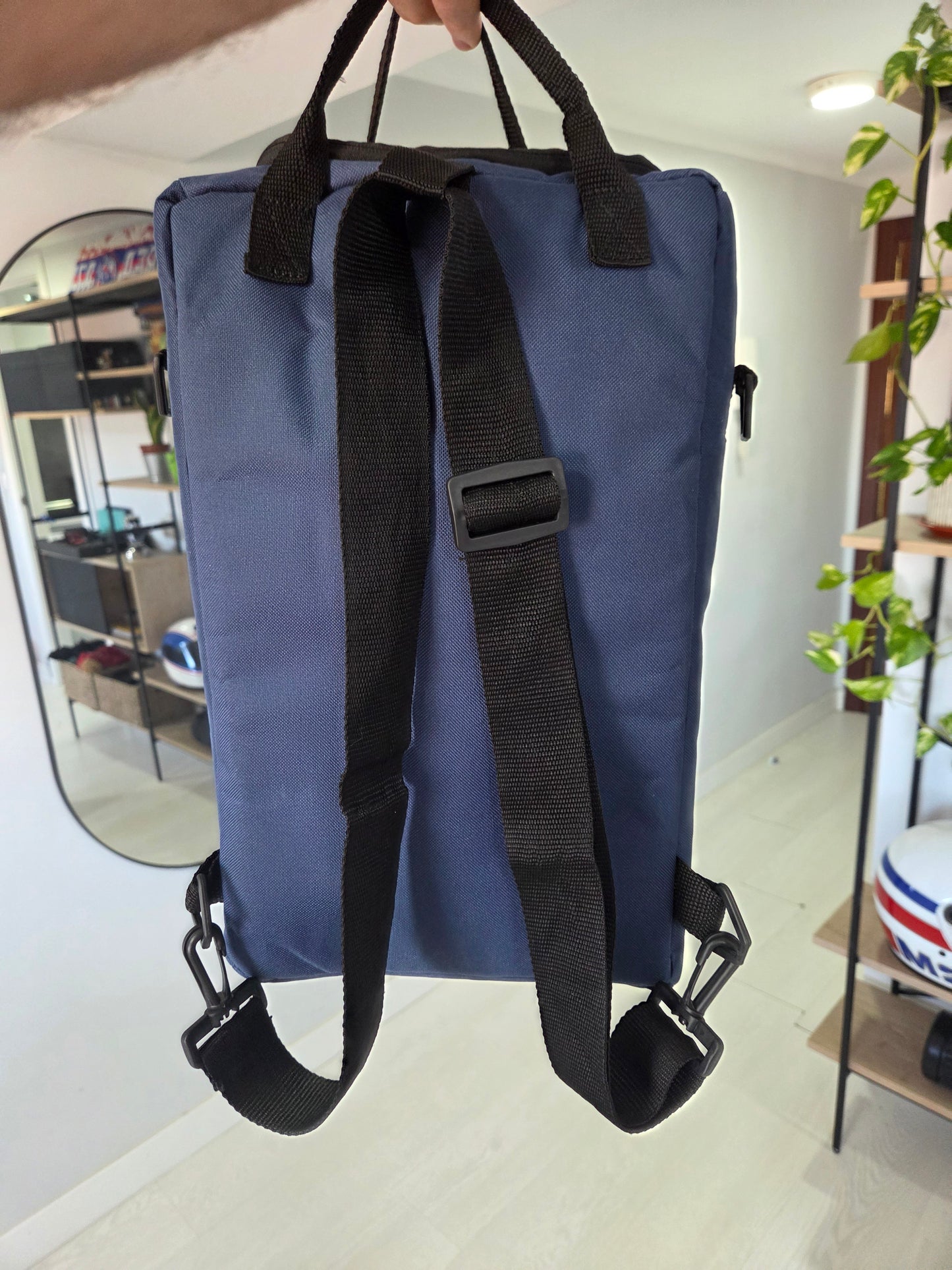 Parte trasera de la mochila matera azul con las correas negras ajustables extendidas para llevar en la espalda.