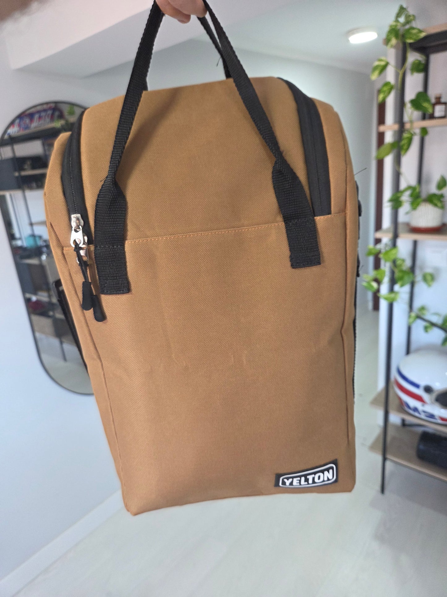 Frente de la mochila matera de tela beige con asas de mano y cierre.