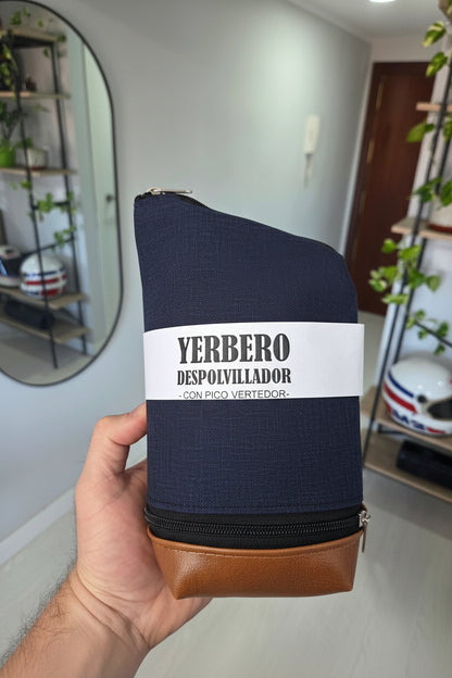 Vista frontal de yerbero quita polvo azul sujeto con la mano, mostrando la etiqueta del producto y cierres.