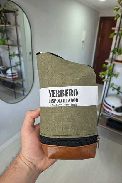 Vista frontal de yerbero quita polvo verde sujeto con la mano, mostrando la etiqueta del producto y cierres.