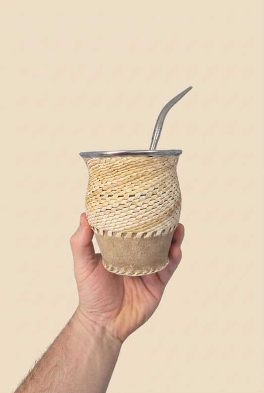Mate Trenzado de Calabaza con bombilla sostenido en una mano sobre fondo beige sin sombras