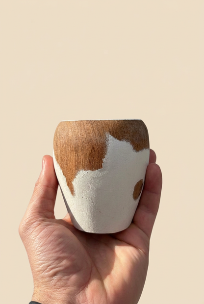 Mate Ranchero de Algarrobo tejano sostenido en una mano sobre fondo beige