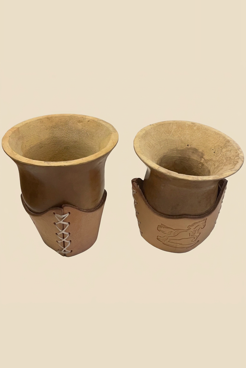 Dos mates criollos de calabaza: uno con base de cuero con costura cruzada y otro con caballo grabado